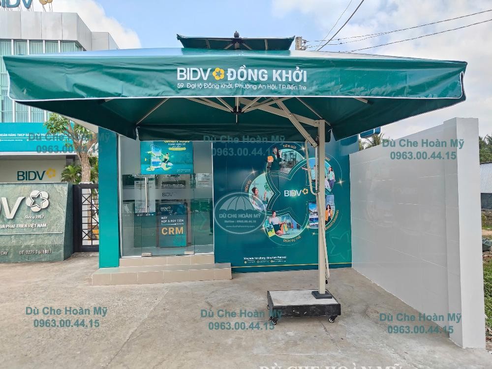 Dù lệch tâm vuông hai tầng màu xanh in logo BIDV Đồng Khởi trước khu vực giao dịch.