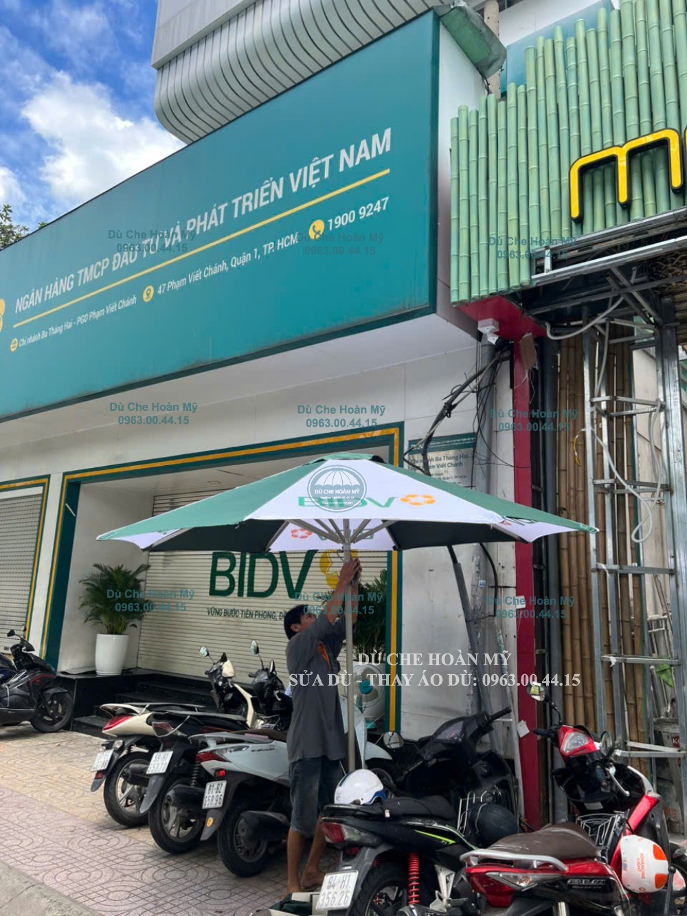 Dù tròn đúng tâm phối xanh–trắng in logo BIDV tại khu vực mặt tiền ngân hàng.