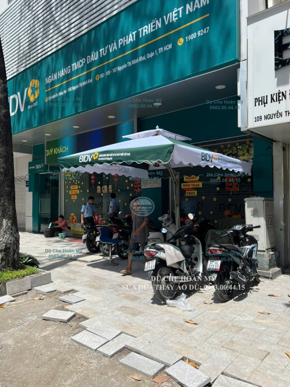 Dù lệch tâm vuông phối xanh–trắng có logo BIDV trước mặt tiền điểm giao dịch.