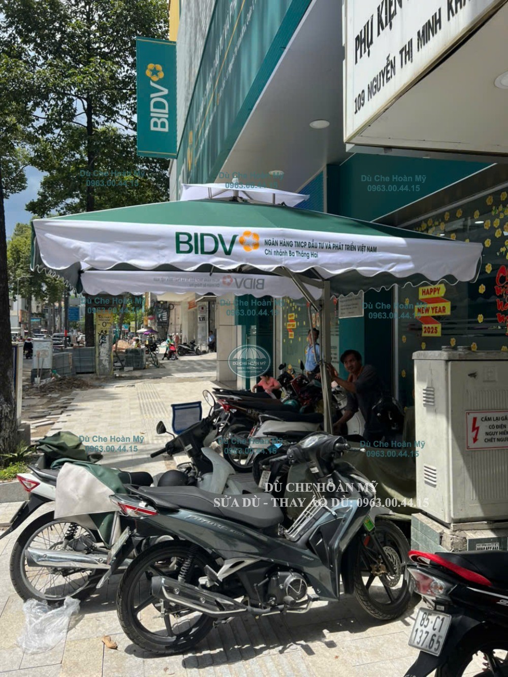 Góc nhìn gần tán xanh–trắng và phần in thương hiệu BIDV trên diềm dù.