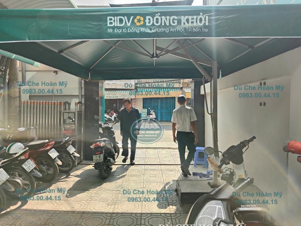 Góc nhìn dưới tán dù BIDV Đồng Khởi cho thấy hệ nan, cột lệch tâm và đế đặt trên nền lát gạch.